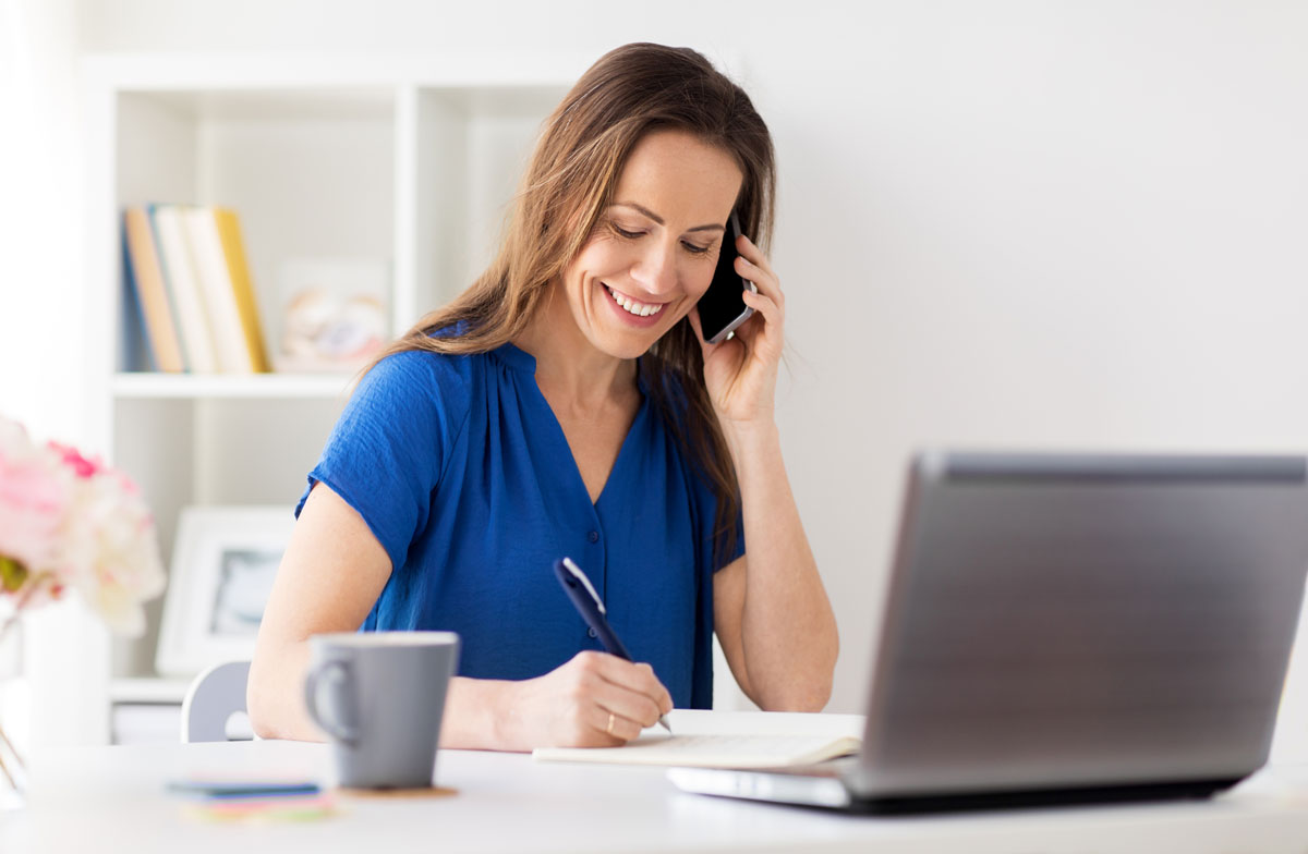 woman-with-notepad-calling-on-smartphone-at