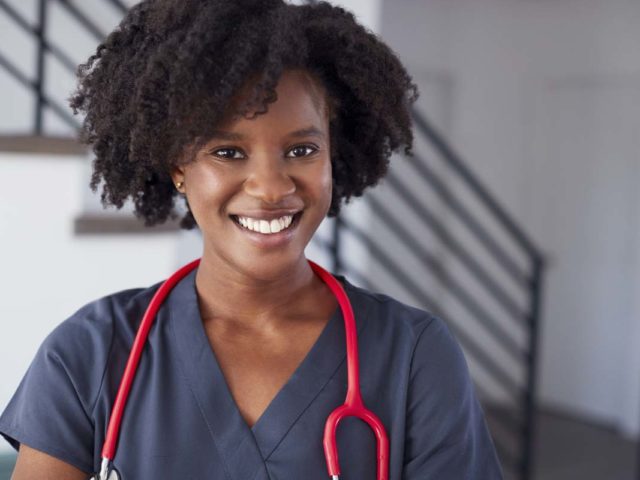 Portrait Of Female Nurse Wearing Scrubs In Hospital