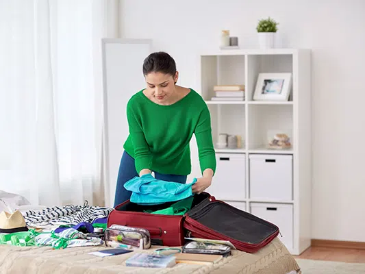 woman-packing-travel-bag-at-home-or-hotel-room-